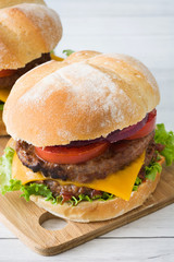 Homemade burgers on a white wood table
