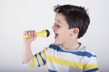 niño cantando con un micrófono 