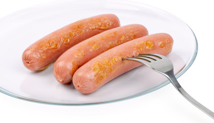 Three delicious frankfurters on a white plate