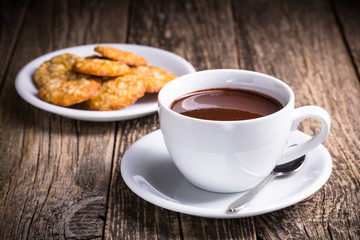 White cup of hot chocolate with homemade oat cookies.