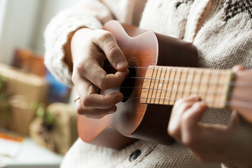 Woman's hand playing ukulele. - obrazy, fototapety, plakaty