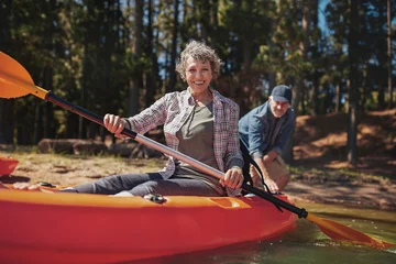 Foto op Canvas Happy senior woman in a kayak at the lake © Jacob Lund