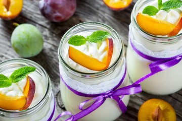 Fresh homemade yogurt with plums, top view