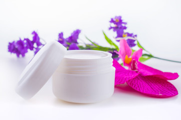 Cream for the hands and face in a jar with pink and purple flowers