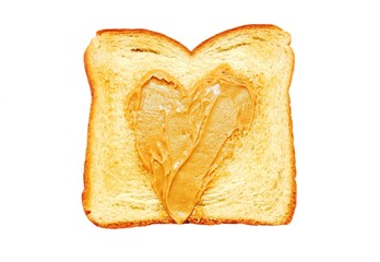 Peanut butter spread in a heart shape on a piece of toast