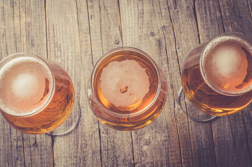 Overhead shot of beer glasses on an old wooden table