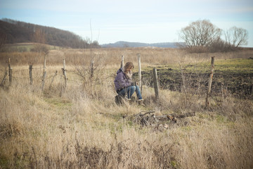 Obraz premium Beautiful young girl posing in autumn cold field iin winter clot
