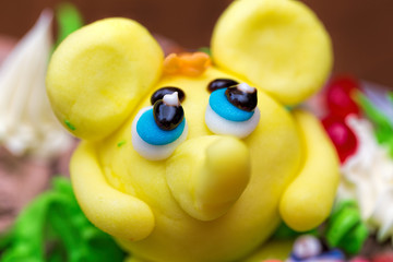 Celebration colorful cake decorated with fruit, chocolate and figures of animals for kids party