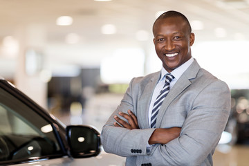 african american car dealership principal standing
