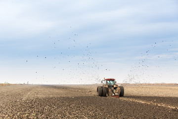Tractor with double wheeled ditcher digging drainage canal