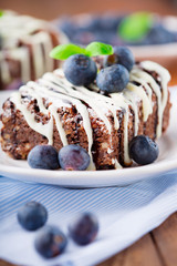 Homemade chocolate brownies with fresh berry and nuts on old rustic wooden background, selective focus