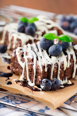 Homemade chocolate brownies with fresh berry and nuts on old rustic wooden background, selective focus