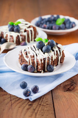 Homemade chocolate brownies with fresh berry and nuts on old rustic wooden background, selective focus