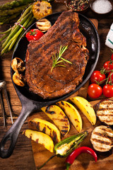 Beef steak with grilled vegetables on wood