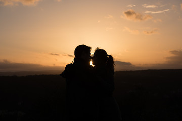 young couple in front of sunset