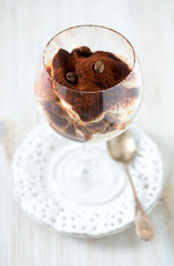 tiramisu in glass on wooden surface