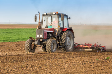 Farmer cultivating arable land before seeding