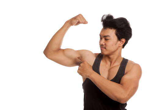 Muscular Asian man point to  flexing biceps