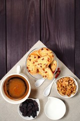 Homemade biscotti are laid out in the form of words next to a large cup of hot black coffee on vintage rustic table