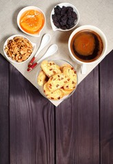 Homemade biscotti are laid out in the form of words next to a large cup of hot black coffee on vintage rustic table