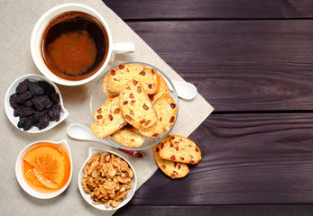 Homemade biscotti are laid out in the form of words next to a large cup of hot black coffee on vintage rustic table