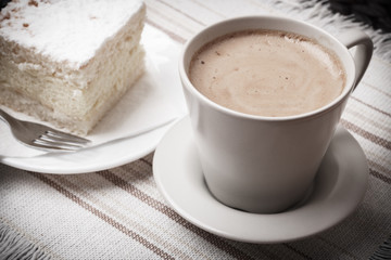 cup with coffee and cake on table