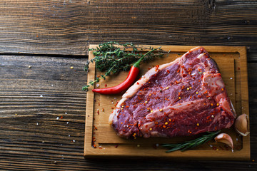 Raw fresh meat T-Bone Steak with herbs and spices and chilli pep