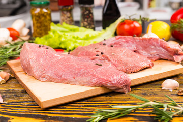 Raw pieces of meat with peppers on top