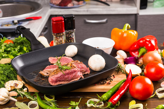 Beef Sizzling in Pan Surrounded by Ingredients