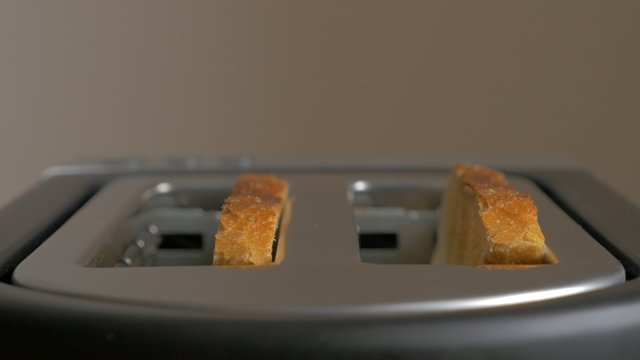 Toasting bread in toaster machine close-up 4K 2160p UHD footage - Making toast in toaster with two bread slices 4K 3840X2160 UHD video