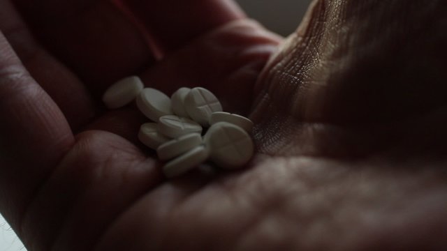Pills drugs tablets in hands macro