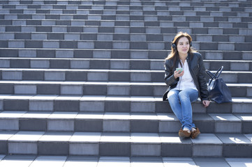 Women are listening to music sitting on the stairs