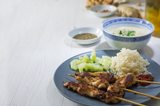 Asian satay meat skewers with rice, cucumber salad and peanut sa