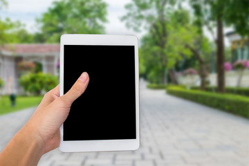 Hands woman are holding touch screen smart phone,tablet on blurred road and building with nature background.