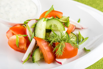 Fresh mixed vegetables salad on white plate

