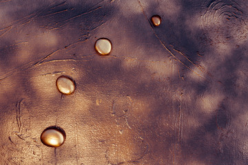 quatre galets en or sur un fond doré aux teintes rose