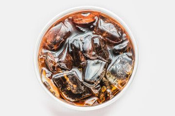 Cola in glass with ice on white background, Top view