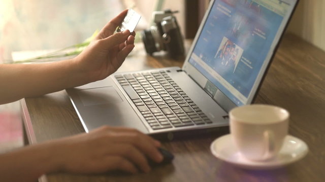 A man paying for online shopping using laptop and credit card. This image is illustrated the online payment concept via internet. Slightly warm tone filter.