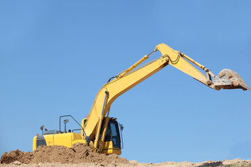 Excavator at a construction site with blue sky