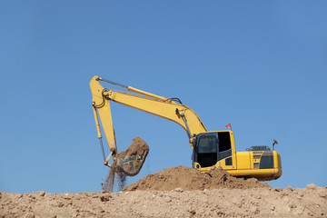Obraz premium Excavator at a construction site with blue sky