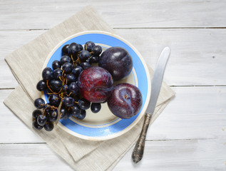 plums and grapes on a plate