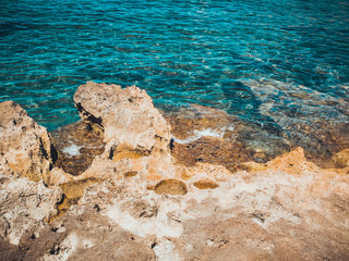 yellow rock and clear blue water