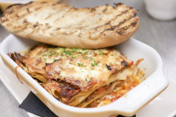 closeup of homestyle lasagna with garlic bread