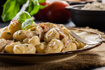Potato gnocchi, Italian potato dumplings with cheese sauce, ham