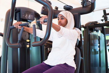 Muslim Woman Exercising in Gym - obrazy, fototapety, plakaty