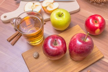 Cider - alcohol hot apple drink and apples on wooden table