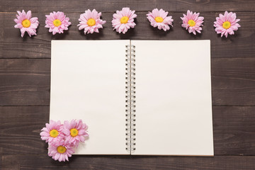 Pink flowers are on a notebook space for your text