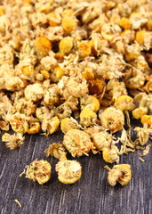 Dried chamomile on wooden table, alternative medicine