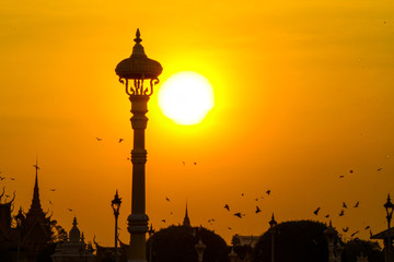 Lamp post with background sunset and flock of birds