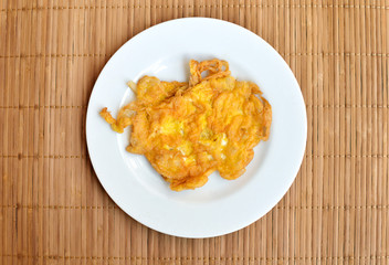 Thai Style Omelet in white ceramic plate  on wood background